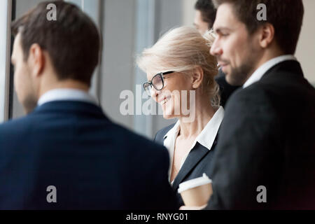 Happy executive businesspeople looking through office window building future plans Stock Photo