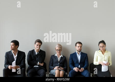 Multi-ethnic applicants sitting in row queue line preparing for interview Stock Photo