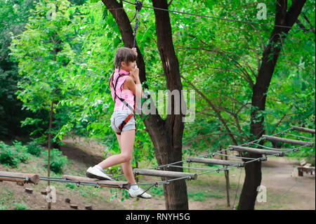 adventure climbing high wire park - hiking in the rope park girl. Stock Photo