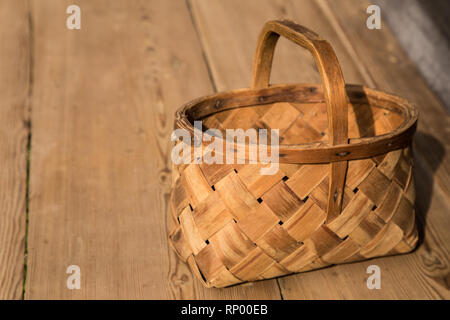 Ancient wicker basket on a wooden background. Selective focus. Free space for text. Stock Photo