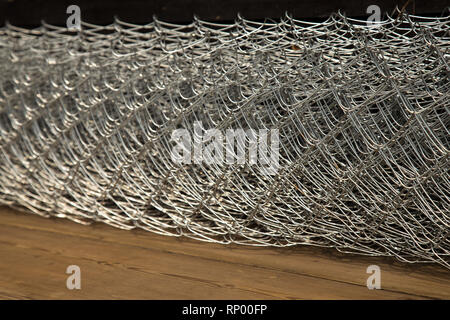Rabitz grid in a roll on a wooden background. Selective focus. Stock Photo