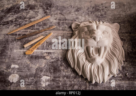 Creation of sculpture from plaster. Lion's head. Plaster workshop. Tooling. Stock Photo