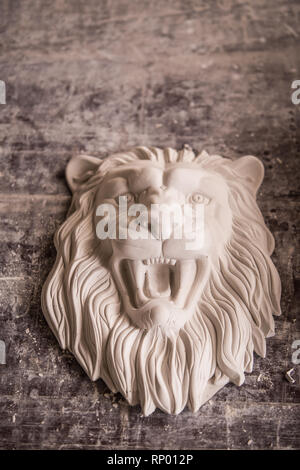 Creation of sculpture from plaster. Lion's head. Plaster workshop. Tooling. Stock Photo