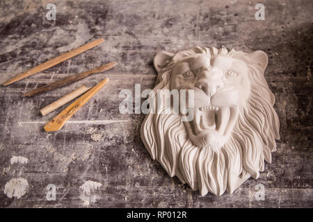 Creation of sculpture from plaster. Lion's head. Plaster workshop. Tooling. Stock Photo