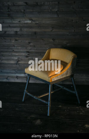 Metal stool with soft upholstery in loft style against a wooden wall. Free space for text. Stock Photo