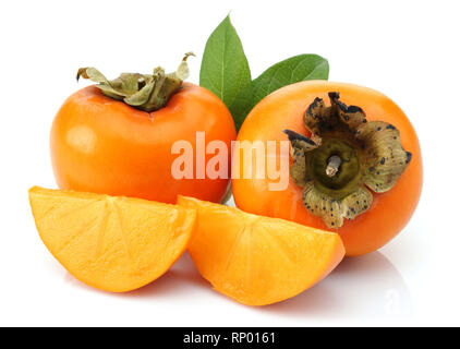 Slice and whole Persimmon with green leaves isolated on white background Stock Photo