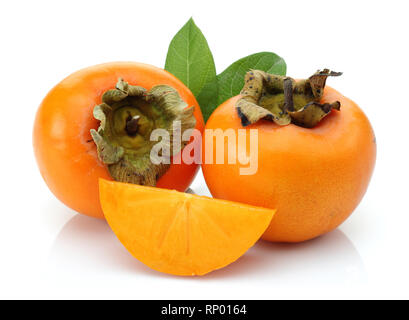 Slice and whole Persimmon with green leaves isolated on white background Stock Photo