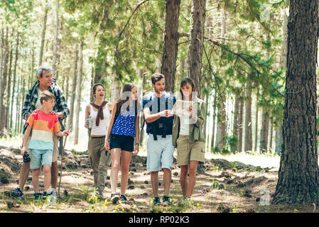 Family reading a map while standing in forest Stock Photo