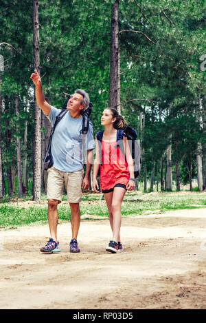 Father and daughter hiking in forest Stock Photo