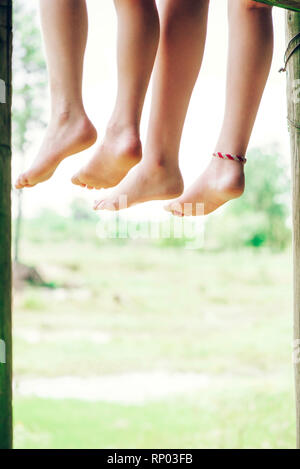 Low section of brother and sister relaxing in forest Stock Photo