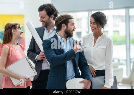 Smiling architects standing in hotel lobby Stock Photo