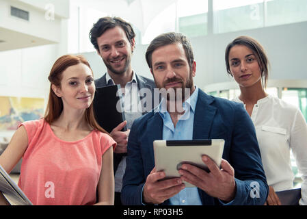 Smiling architects standing in hotel lobby Stock Photo