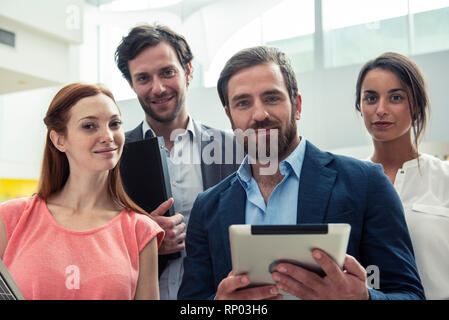 Smiling architects standing in hotel lobby Stock Photo