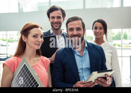 Smiling architects standing in hotel lobby Stock Photo