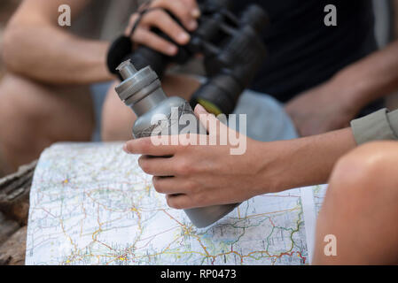 Young couple reading map while sitting in the forest Stock Photo