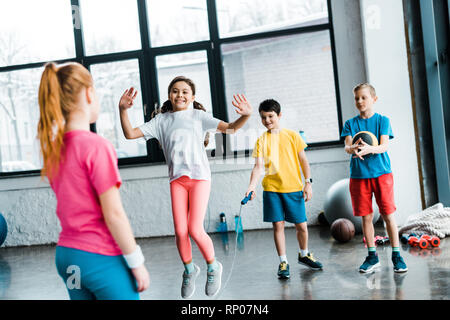 Inspired kids jumping with skipping rope in gym Stock Photo