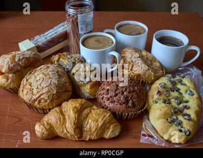 Nut Raisin Muffin, cakes, roll and caps of coffee on a brown wooden table. Close up. Selective focus. Stock Photo