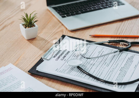 clipboard with compensation claim form and stethoscope on office desk Stock Photo