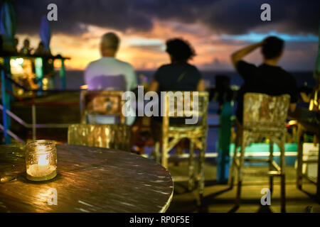 Outdoor restaurant in balinese style on sunset sea background Stock Photo