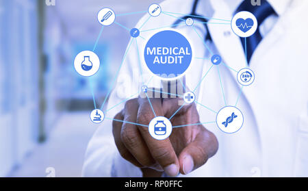 Closeup of medical audit text button pressed by indian doctor man with index finger on invisible display as futuristic technology concept Stock Photo