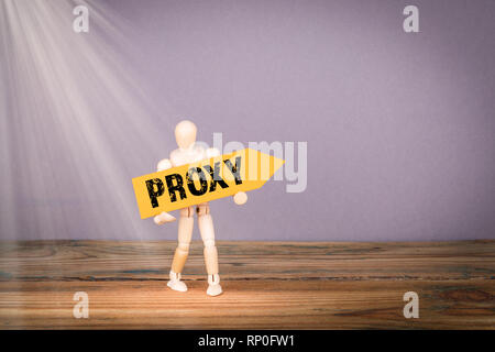 Proxy concept. Wooden man with yellow an arrow Stock Photo