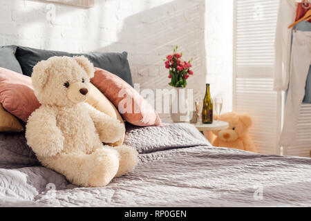 selective focus of teddy bear toy on bed in modern bedroom with copy space Stock Photo