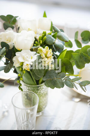 Beautiful festive table setting with elegant white flowers and cutlery, dinner table decoration closeup Stock Photo