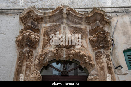 facade of a baroque house in Ostuni, Puglia, Italy - Apulia. part of Old wooden  marble door Stock Photo