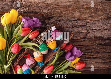 Easter holiday concept with eggs and tulips on old wooden background. View from above with copy space Stock Photo