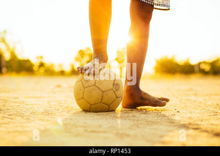 sport outdoor picture of kids having fun playing soccer football for exercise under the twilight sunset sky. Stock Photo