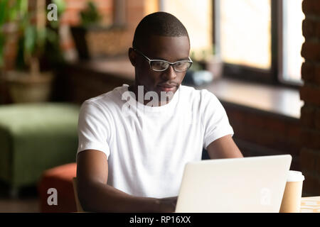 Focused black millennial guy working on computer Stock Photo