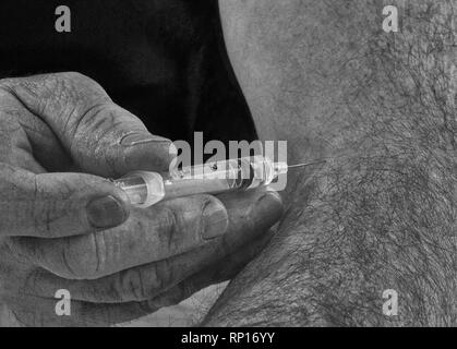 An close up image in back and white of a man holding a syringe with the needle inserted into his arm having just injected himself with its contents Stock Photo