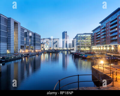 Modern buildings reflected in Leeds Dock at dusk Leeds West Yorkshire England Stock Photo