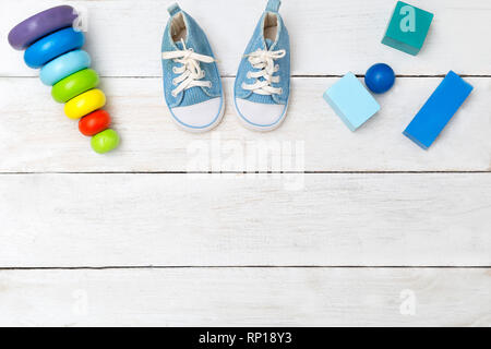 Shoes for little boy and wooden cubes on a wooden background Stock Photo