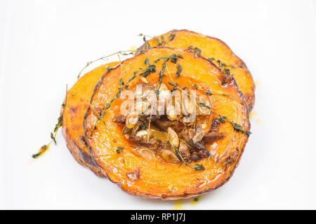 Rounds of butternut squash  with the skin left on and seeds left in bought from a supermarket that have been roasted in the oven with olive oil, crush Stock Photo
