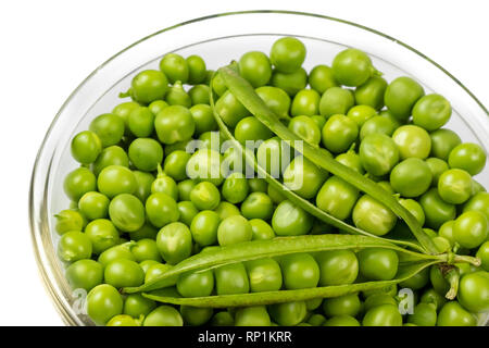 Fresh green peas in glass bowl isolated on white background. Stock Photo