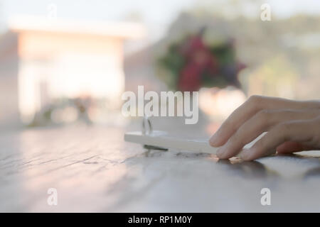 hand holding key chain on the wooden table with blurred foreground and boqeut background Stock Photo