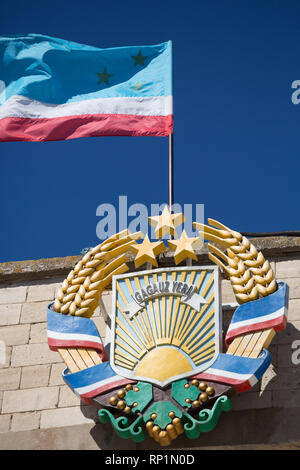 31.08.2016, Comrat, Gagauzia, Moldova - The coat of arms of the Autonomous Region of Gagauzia on the government building, as well as the national flag Stock Photo