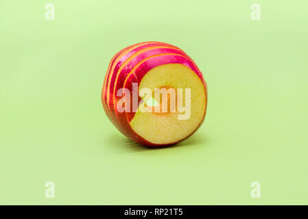 fresh ripe red apple sliced in circles. green background Stock Photo