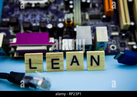 Word LEAN on the wooden blocks with computer mainboard in the background. Computer technology concept image Stock Photo