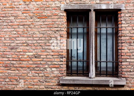 Old house with copy space on the red bricks wall. Old wooden windows with metal bars on the old brick house Stock Photo