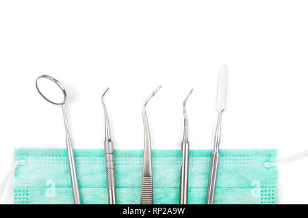 Dentist's tools and mask on white background. Stock Photo