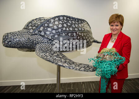 Glasgow, UK. 20 February 2019. Nicola Sturgeon declares war on plastics, leading the change in policy in her opening conference speech. She is pictured holding a turtle trapped in plastic netting and plastic marine pollution standing right next to a huge life size leatherback turtle.  Leatherback turtles are particularly in danger as they eat plastic pollution thinking it is food.  Marine life also get strangled within plastic netting left behind by fishermen and the animal then becomes trapped and dies. Credit: Colin Fisher/Alamy Live News Stock Photo