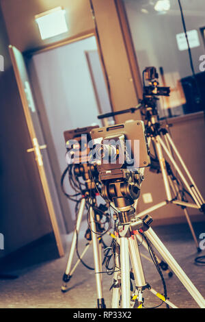 Film camera on a tripod in a television broadcasting studio, spotlights and equipment Stock Photo