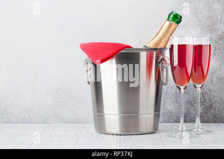Rose wine champagne bottle in bucket and glasses. With copy space Stock Photo
