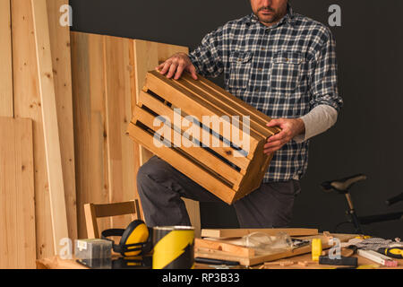 Carpenter making wooden crate in small business woodwork workshop, craftsman working on DIY project Stock Photo
