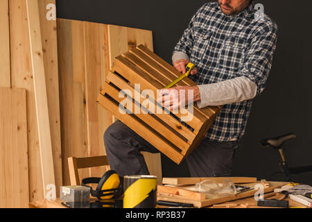 Carpenter making wooden crate in small business woodwork workshop, craftsman working on DIY project Stock Photo