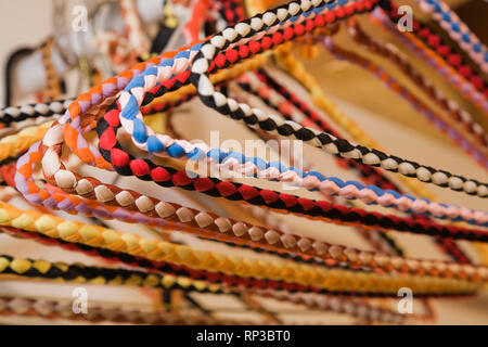 Colourful braided clothes hangers in closet Stock Photo