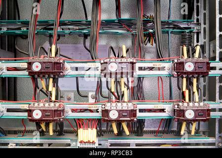 Old contactors and safety relays for emergency stop monitoring in control cubicle. Closeup. Stock Photo