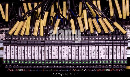 Modern terminal blocks with multi colored wires. Black wires with caption fields. Closeup Stock Photo